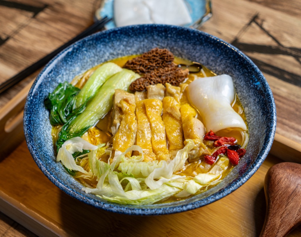Rice noodle bowl with chicken and greens